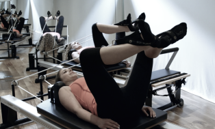 Frog pressing on the Pilates Reformer at Peacock Pilates London - Great way to work glutes and hamstrings.
